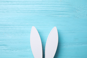 Decorative bunny ears and space for text on light blue wooden background, flat lay. Easter holiday
