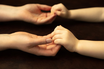 Holding hands, clapping like friends. Close up shot of female and kid's hands doing different things together. Family, home, education, childhood, charity concept. Mother and son or daughter, wealth.