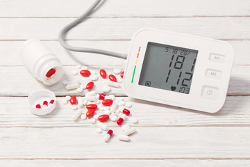 modern tonometer with pills on wooden background