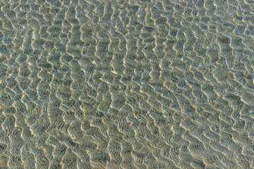 Shallow of sea on sand beach close up. Beautiful soft waves, sea beach background.
