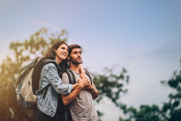 Portrait of happy couple man and woman tourist smiling and having fun in hiking trip in summer