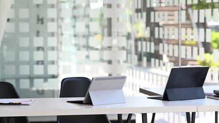 Workplace. Two computer tablet with keyboard case putting together on modern working long table. Comfortable office concept.