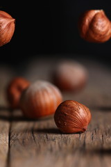 a hazelnut and a broken shell close up on a cracked wooden table