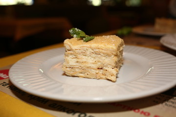 a piece of cake Napoleon lies on a plate in a restaurant, close-up