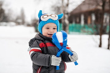 Fototapeta na wymiar little happy boy child playing snowballs in winter