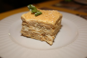 a piece of cake Napoleon lies on a plate in a restaurant, close-up