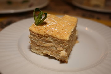 a piece of cake Napoleon lies on a plate in a restaurant, close-up