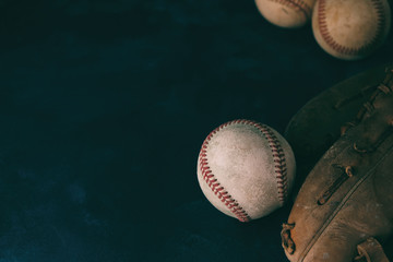 Baseball flat lay background with used balls by old leather glove.