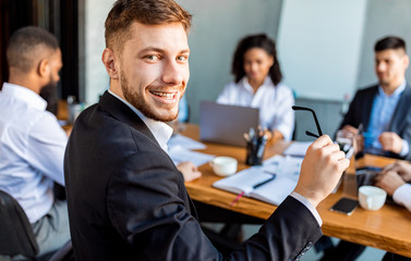 Businessman At Meeting With Colleagues Smiling Sitting In Modern Office