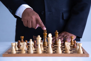  Businessman leadership hand moving of playing chess   concept: symbol confident new strategy plan for win and success,  sports game  thinking battle planning object achievement queen for successful