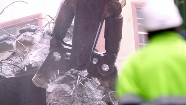 demolition excavator in bridge destruction site and worker unfocused with hardhat protection , video hd footage