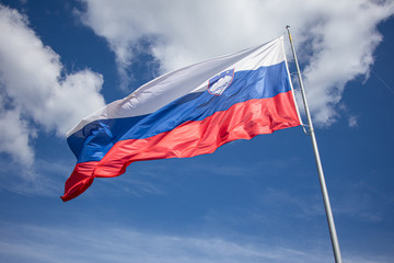 Naklejka na ściany i meble Slovenia flag on sky background. Eastern Europe