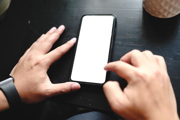 Close up of man using cell phone,sending massages on the coffee shop with black screen,texting,video calls.