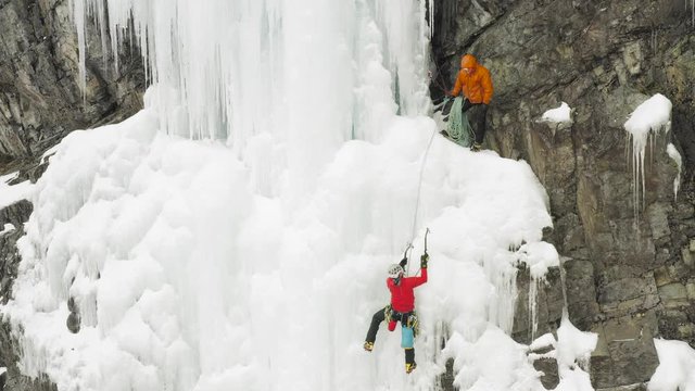 Two extreme mountain climbers scale frozen cascade Maineline, Mount Kineo 