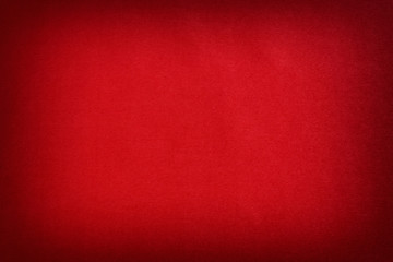 Textured synthetic material in red, background. Vignette.