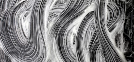 Selbstklebende Fototapeten Foamy wawe stains on black surface. Abstract texture grunge background. © Liliia