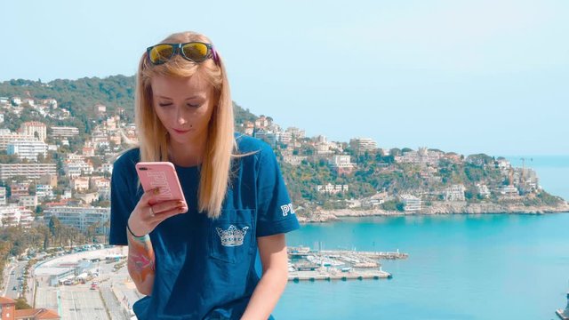 Woman texting sending a message on smartphone and laughing with landscape in background 4k 25fps
