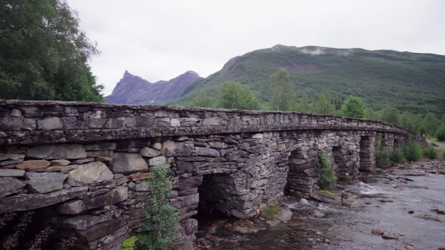 Old stone bridge with a high sharp mountain peak in the background - Norwegian mountain scenery
