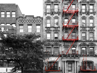 Red fire escape on the exterior of an old building in black and white - Manhattan, New York City - 326462923