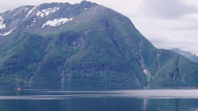 High mountains rising from deep blue fjord in Norway - including a sailboat