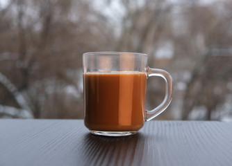 a cup of coffee on the windowsill of an open window