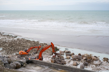 Picardie. Caux. deux bulldozers renforcent un brise-lames pour briser les vagues de l'oc&eacute;an Atlantique.