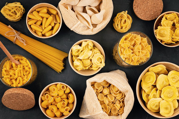 Flat lay with different types of traditional italian pasta. Penne, tagliatelle, fusilli, farfalle, spaghetti and others. Traditional italian cusine concept. Top view