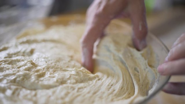acro shot of baker cook chef getting the organic unruly dough  or yeast cake to prepare bread pizza pasta or a cake in a restaurant. Food concept.