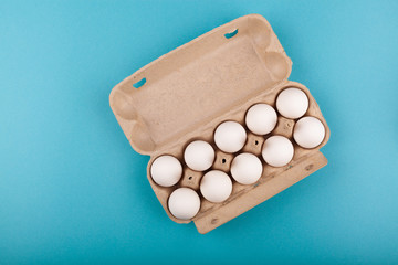 Egg Chicken eggs. Top view of an open gray box with white eggs. Isolated on a blue background. The concept of a healthy lifestyle, getting pure protein. Proper Breakfast. Ten eggs.