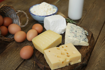 assortment of cheese and cottage cheese and bottle of milk and chicken eggs. Organic farm dairy products and eggs.
