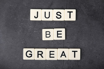 A motivational quote Just be great formed with tile letters	