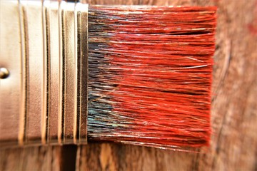 pennello per colorare di colore rosso un vecchio tavolo di legno