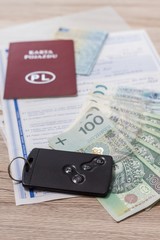 Umowa zakupu auta leży na stole. Banknoty PLN i karta do auta leżą na dokumentach zakupu. - obrazy, fototapety, plakaty