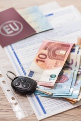 Umowa zakupu auta leży na stole. Banknoty Euro i kluczyki leżą na dokumentach zakupu. - obrazy, fototapety, plakaty