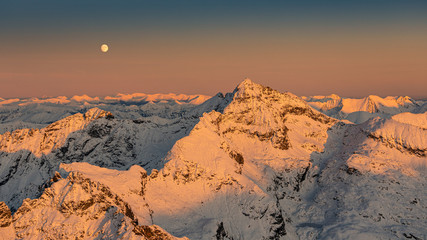 sunset above the alps with a moon