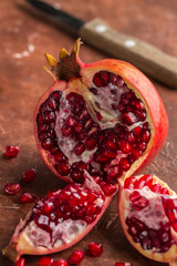 Ripe juicy organic cut pomegranate on a dark background. Fresh fruit. Vitamins. Healthy diet. Selective focus