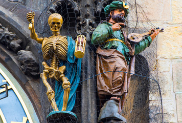 Naklejka premium Statues of Skeleton or Death and Turkish Man on Tower with Prague Astronomical Clock Orloj