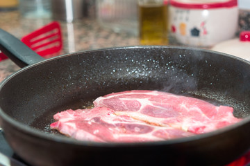 Cooking beef in a pan at home.