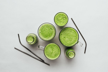 Cucumber vegan smoothie in many glasses, nutrient hydrating green juice, detox food, weight loss concept, white background, top view ,metal straw,zero waste