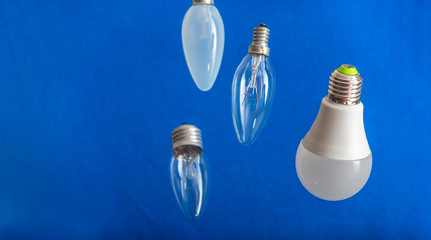 Different bulbs fall down. Electric lighting. Blurred background. Power saving LED lamps in...
