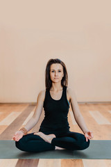 young attractive brunette girl practicing yoga from the Studio