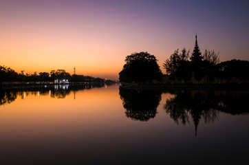 Mandalay Palace wall with reflection in moat, picturesque silhouette with twilight sky in sunset, Myanmar