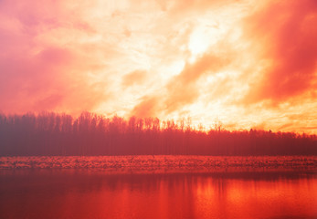 Burning sunset on winter river background