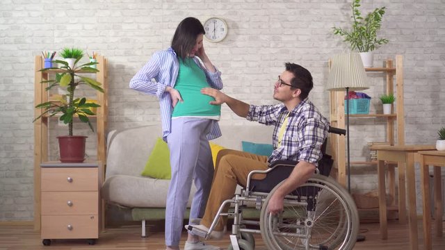 disabled man in a wheelchair and his pregnant wife future parents