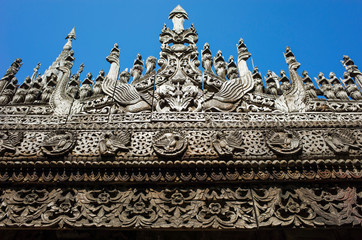 Carvings of Buddhist myths on ancient teak Shwenandaw monastery (Golden palace) in traditional...