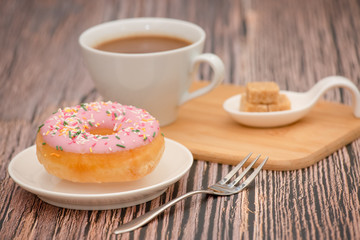 Dessert, Donuts, chocolate and strawberry circles, sugar and cream on Donuts and hot coffee cups, preparation for a break or party on the wooden table background.