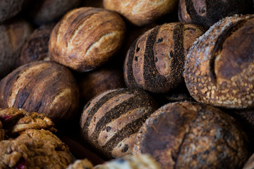 large assortment of freshly baked bread at local bakery, stacked loaves, artisan loaf of bread