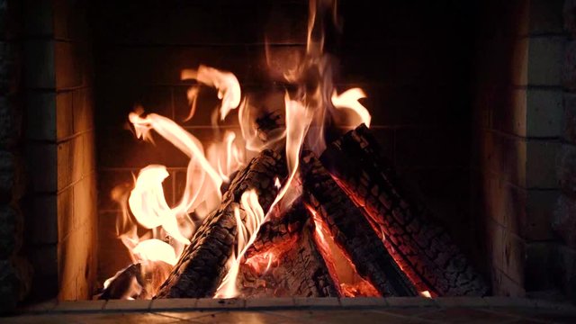 Burning fire in the fireplace in country house. 4K video, slow motion.