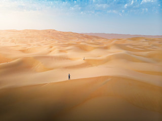 Fototapeta na wymiar Couple among desert sand dunes aerial view