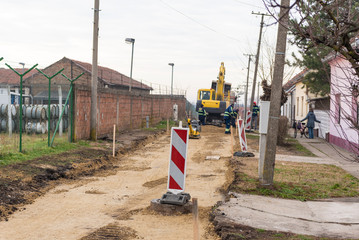 Workers with machinery preparing the road for new asphalt
